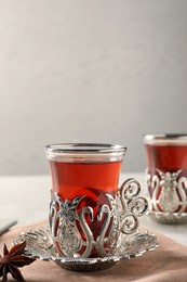 Photo of Glasses of traditional Turkish tea in vintage holders on table