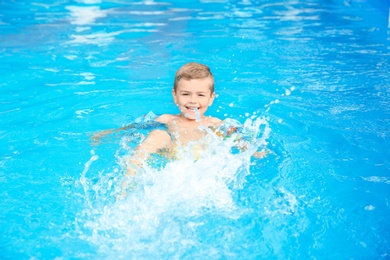 Little boy in swimming pool on sunny day