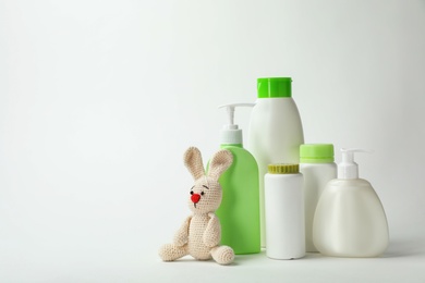 Photo of Baby cosmetic products and toy on white background