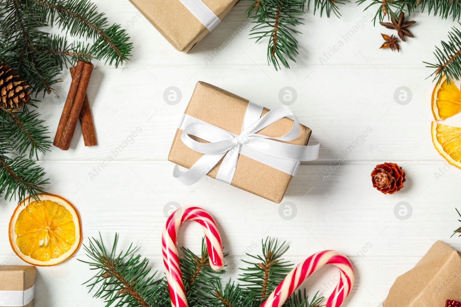 Photo of Flat lay composition with Christmas gift boxes and festive decor on white wooden table