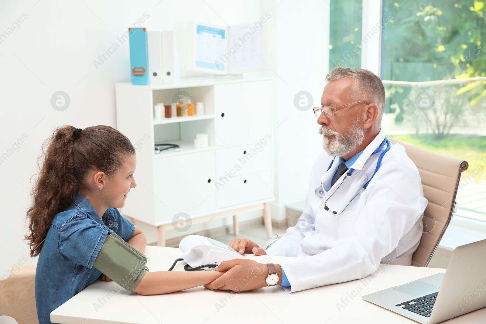 Photo of Doctor checking little girl's pulse in hospital