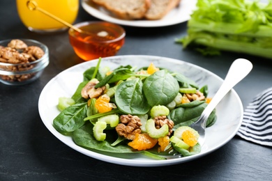 Photo of Delicious fresh celery salad on black table, closeup