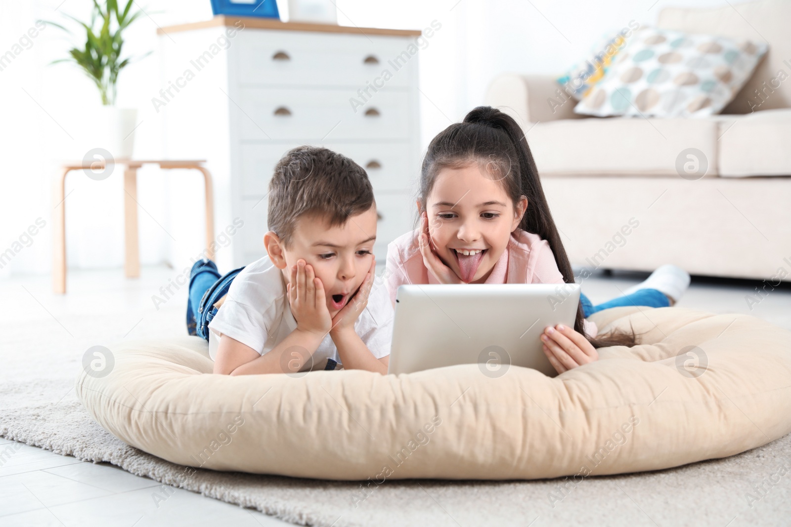 Photo of Little children using video chat on tablet at home