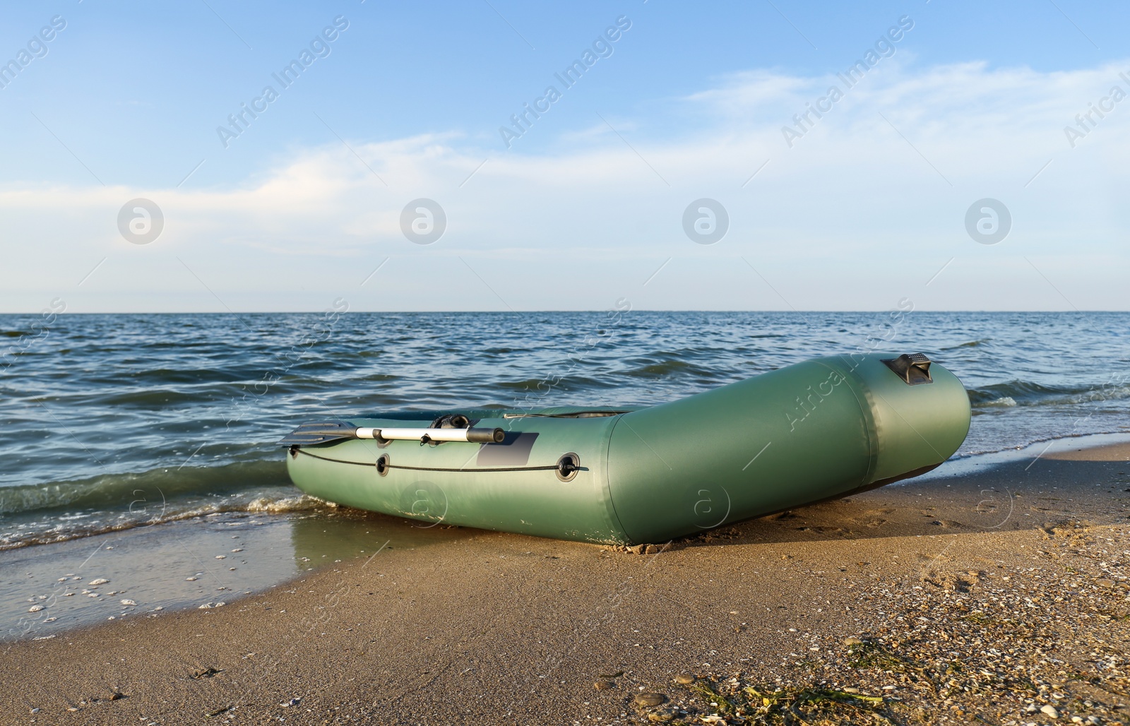 Photo of Inflatable rubber fishing boat on sandy beach near sea