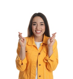 Photo of Excited young woman holding fingers crossed on white background. Superstition for good luck 