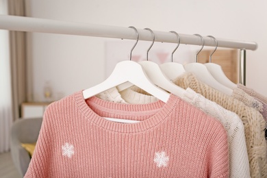 Wardrobe rack with warm clothes indoors, closeup