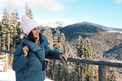 Photo of Happy young woman spending winter vacation in mountains. Space for text