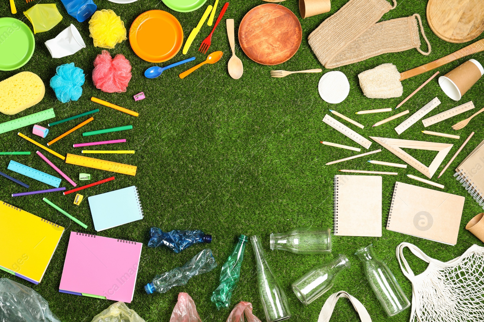 Photo of Flat lay composition with household goods on green grass, space for text. Recycling concept