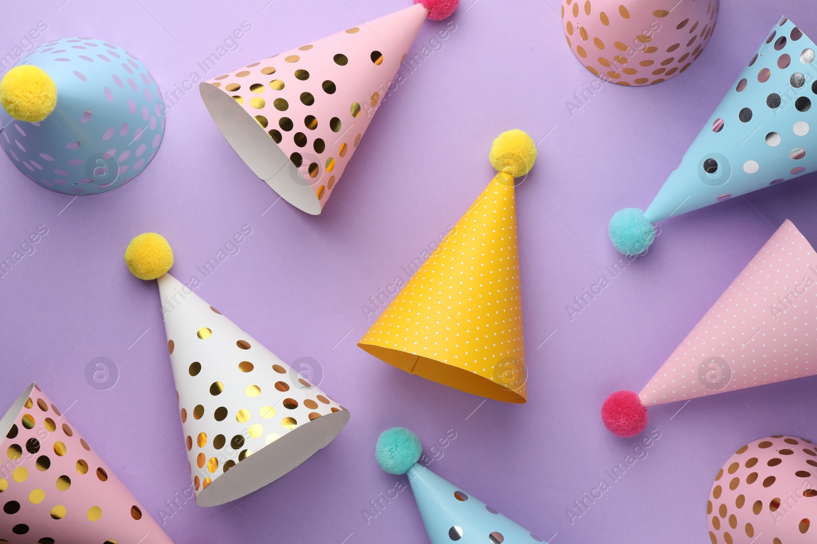 Photo of Beautiful party hats on purple background, top view