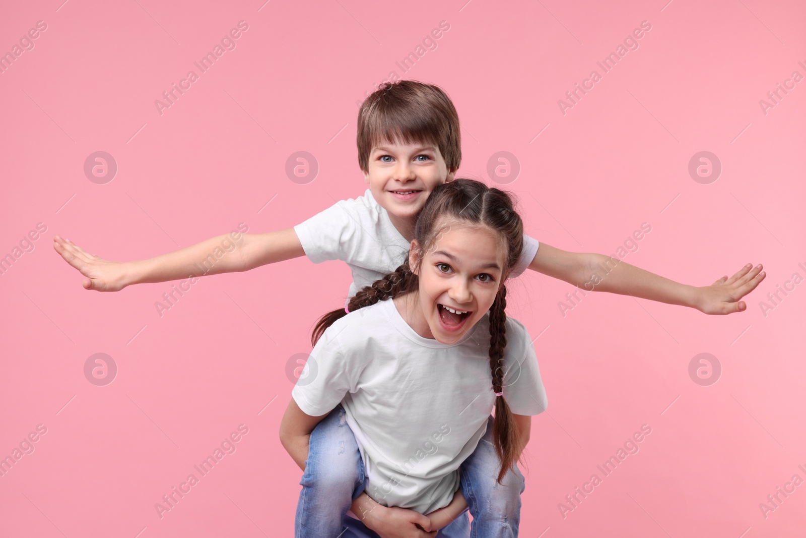 Photo of Happy brother and sister on pink background