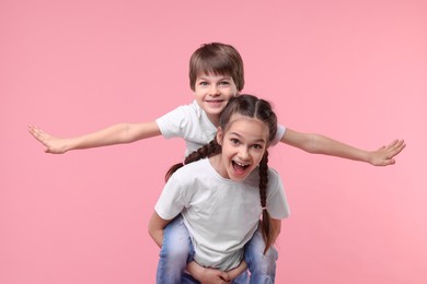 Happy brother and sister on pink background