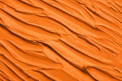 Image of Strokes of orange oil paint as background, closeup