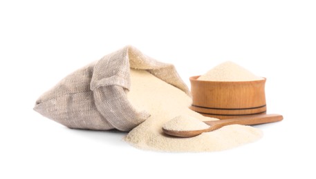 Bag, jar and spoon with semolina on white background