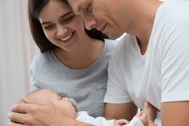 Photo of Happy family with their cute sleeping baby on grey background