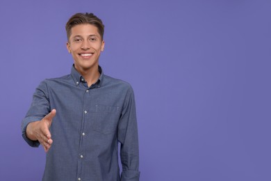 Photo of Happy man welcoming and offering handshake on purple background. Space for text