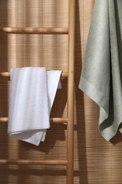 Photo of Soft terry towels and wooden ladder indoors