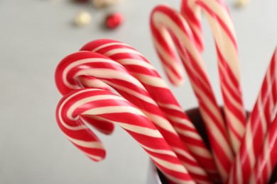 Photo of Sweet Christmas candy canes on light background, closeup
