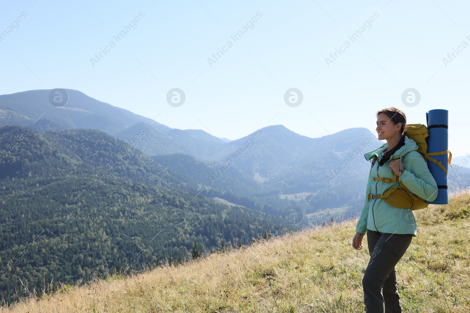 Photo of Tourist with backpack enjoying view in mountains on sunny day