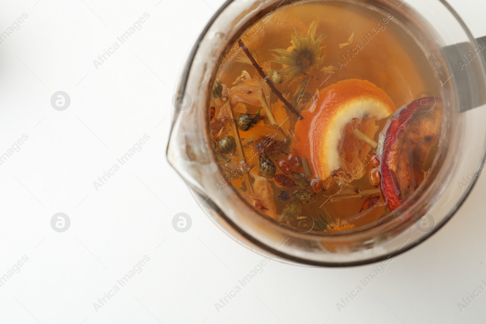 Photo of Freshly brewed herbal tea on white background, top view. Space for text