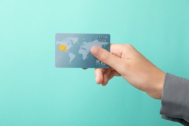 Photo of Woman holding credit card on color background