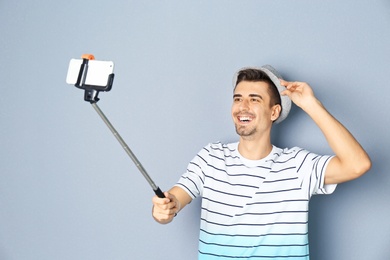 Young handsome man taking selfie against grey background