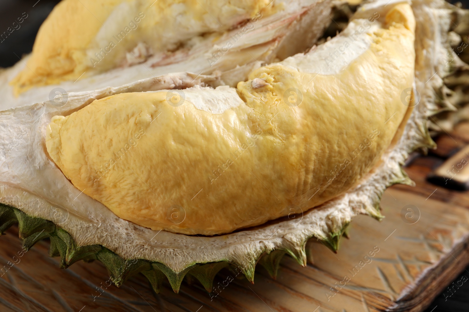 Photo of Fresh ripe durian on wooden board, closeup