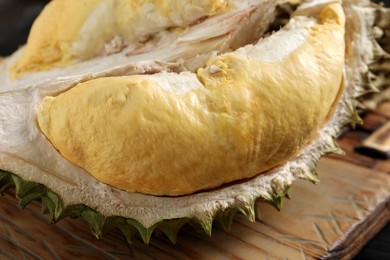 Photo of Fresh ripe durian on wooden board, closeup