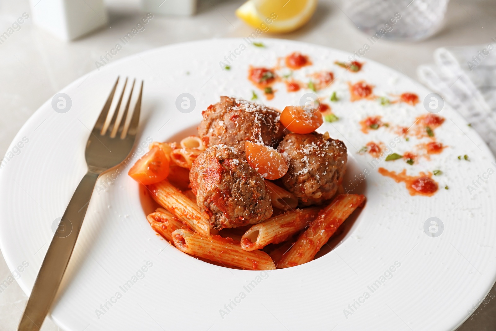 Photo of Delicious pasta with meatballs and tomato sauce on plate, closeup