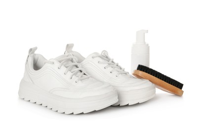 Stylish footwear and shoe care accessories on white background