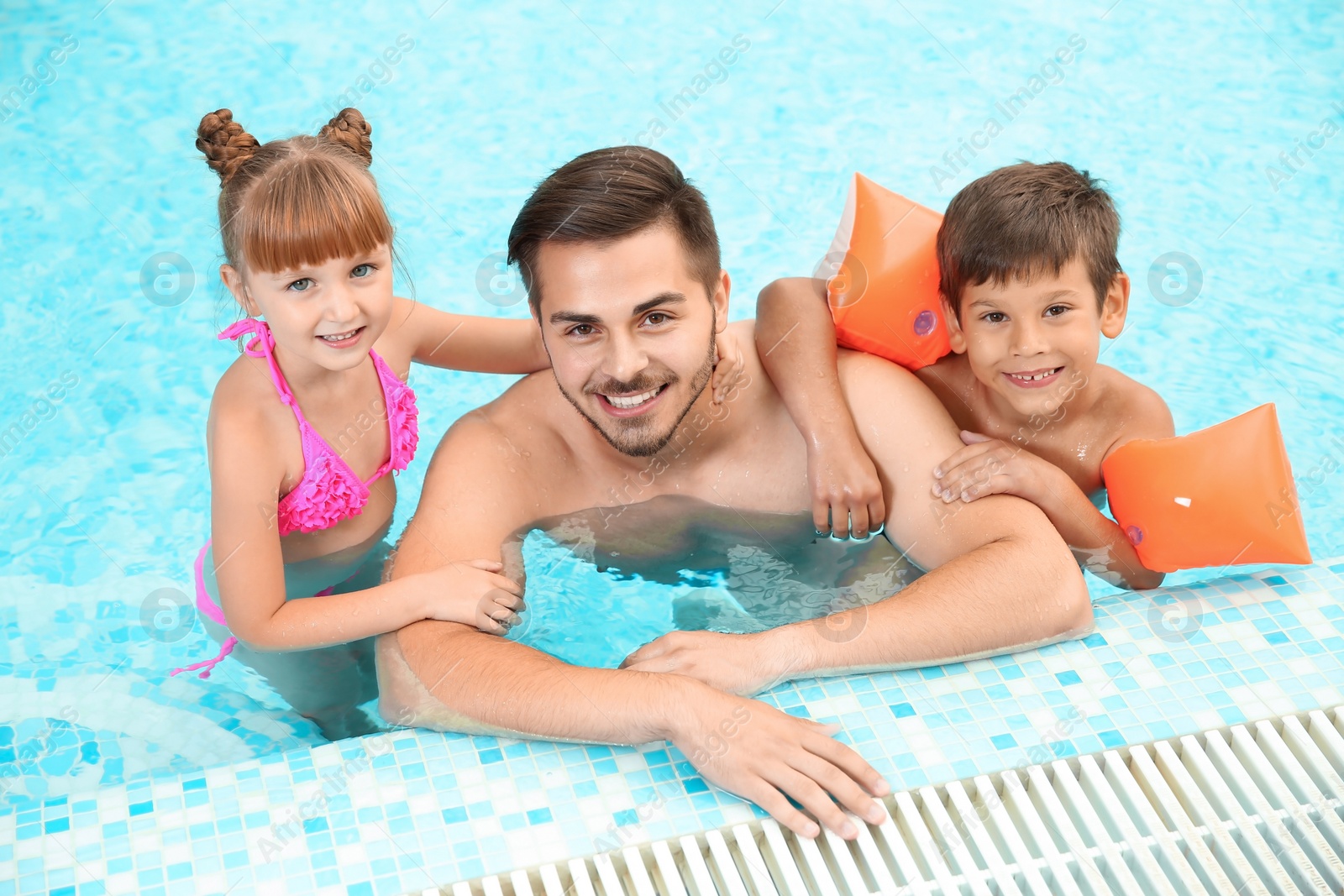 Photo of Happy father with children in swimming pool