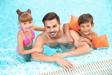 Happy father with children in swimming pool