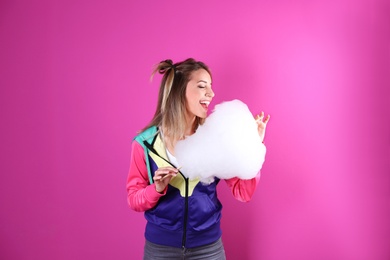 Photo of Young pretty woman with cotton candy on colorful background