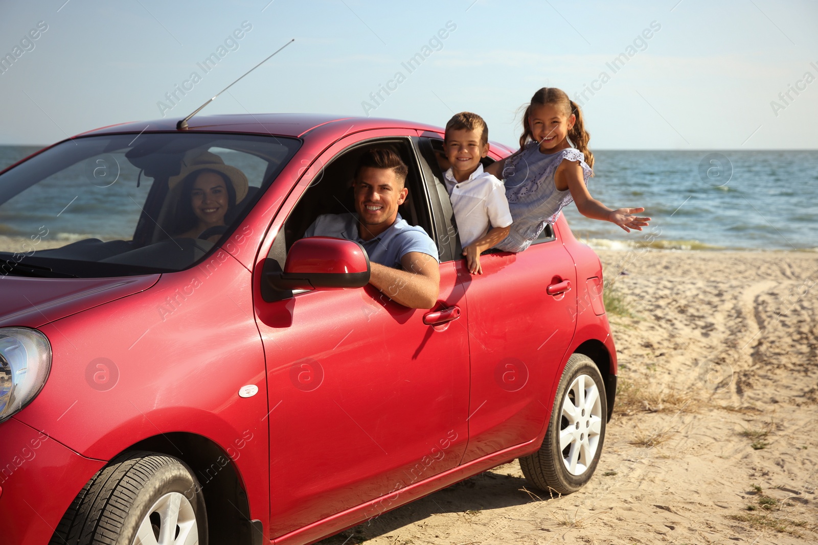 Photo of Happy family in car near sea. Summer trip