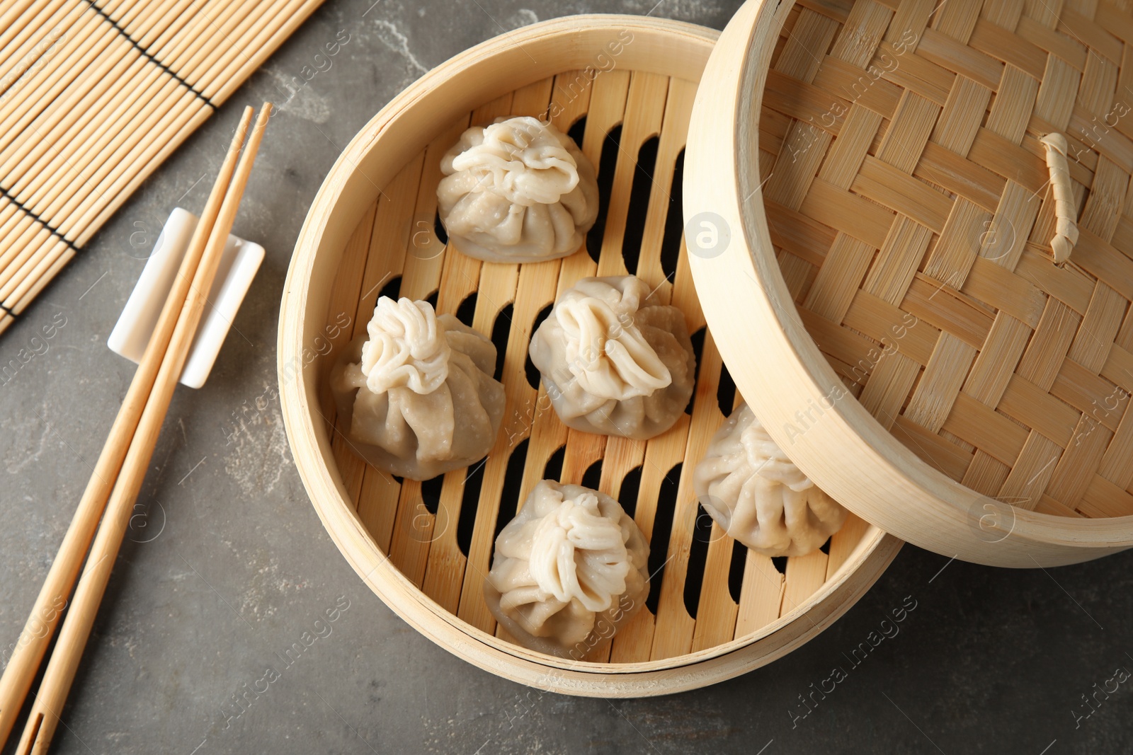 Photo of Bamboo steamer with tasty baozi dumplings on table, top view