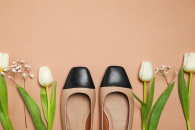 Photo of Flat lay composition with pairnew stylish square toe ballet flats and beautiful flowers on beige background. Space for text