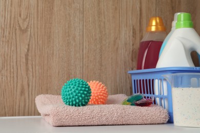Dryer balls, detergents and clean towel on washing machine. Space for text