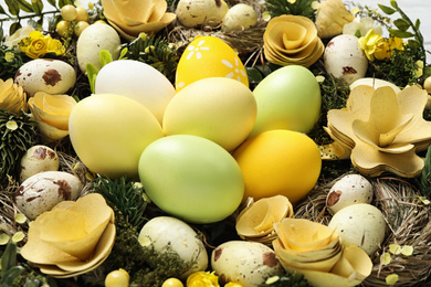 Photo of Decorative wreath with Easter eggs as background, closeup