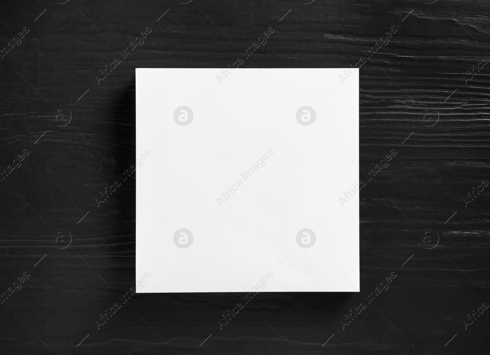 Photo of Stack of blank paper sheets for brochure on black wooden background, top view. Mock up