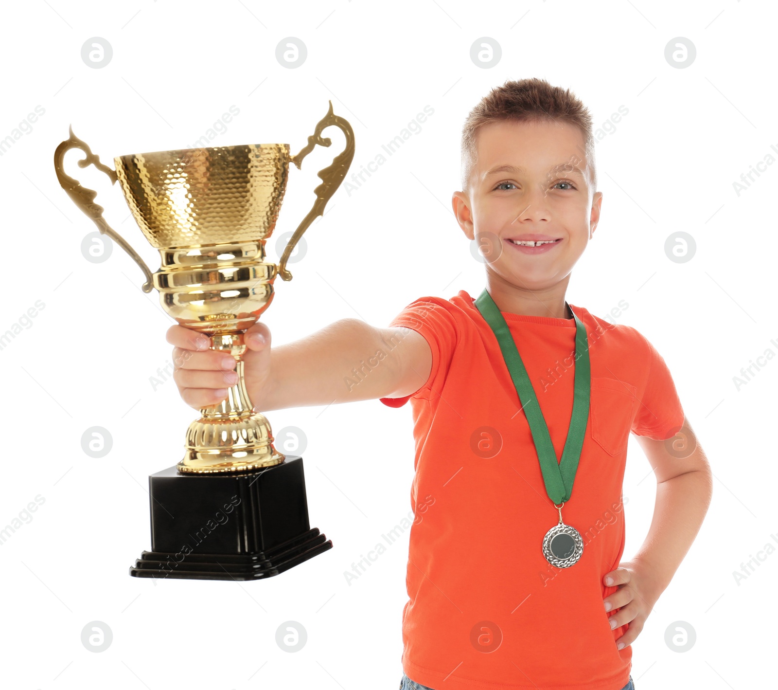 Photo of Happy boy with golden winning cup and medal isolated on white