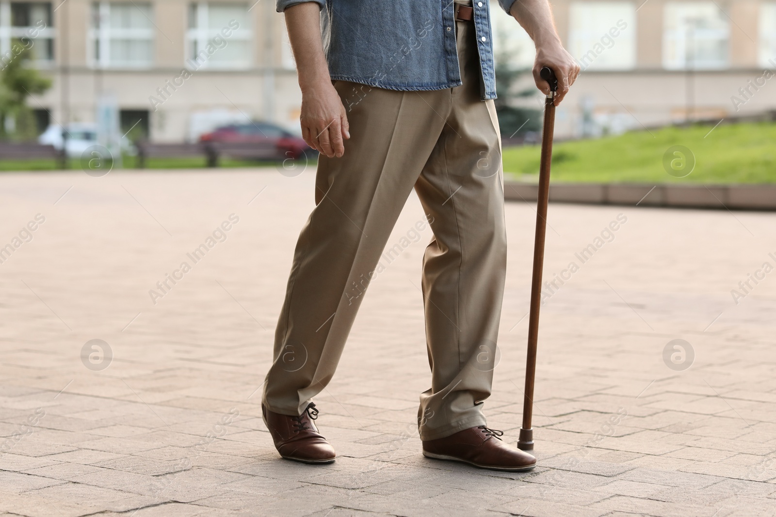 Photo of Senior man with walking cane outdoors, closeup