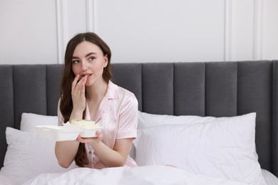 Photo of Beautiful young woman with her Birthday cake on bed in room