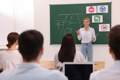 Teacher giving lesson to audience in driving school