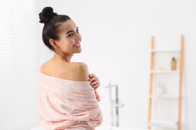 Photo of Beautiful happy woman wearing stylish bathrobe in light bathroom. Space for text