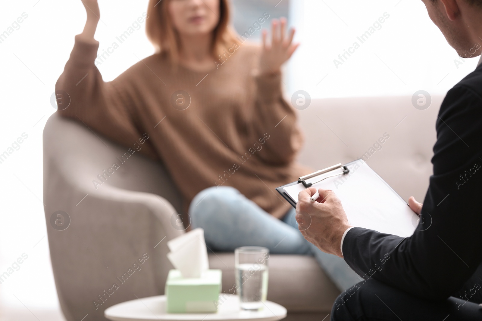 Photo of Psychotherapist working with woman in office, closeup