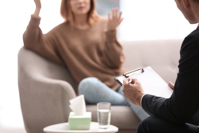 Psychotherapist working with woman in office, closeup