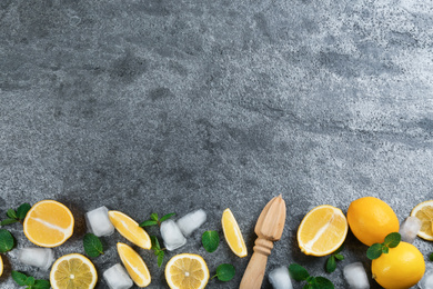 Photo of Lemonade layout with juicy lemon slices, mint and ice cubes on grey table, top view. Space for text
