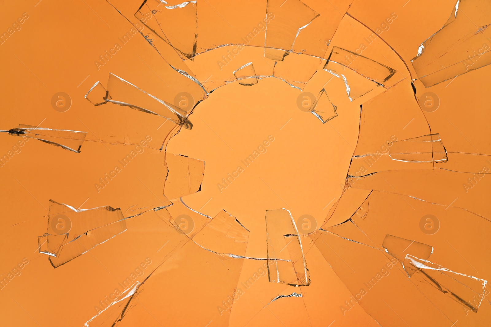 Image of Broken glass with cracks on orange background