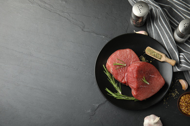 Photo of Flat lay composition with fresh beef cut on black table. Space for text