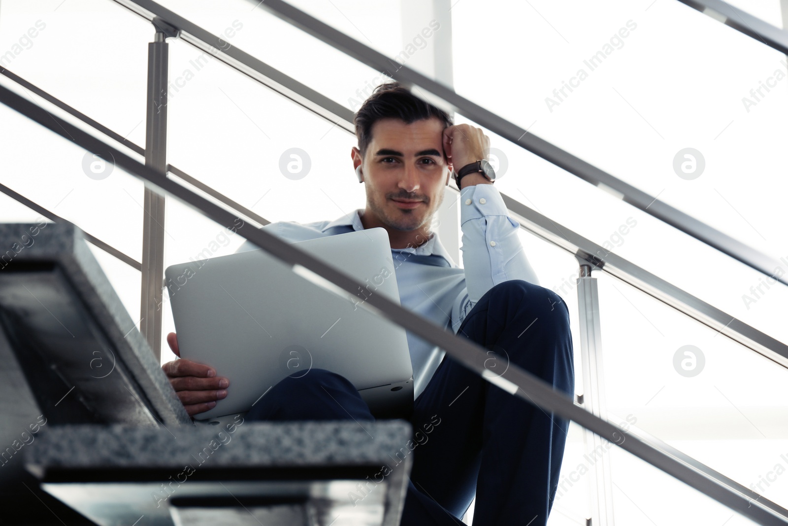 Photo of Portrait of young man with laptop indoors