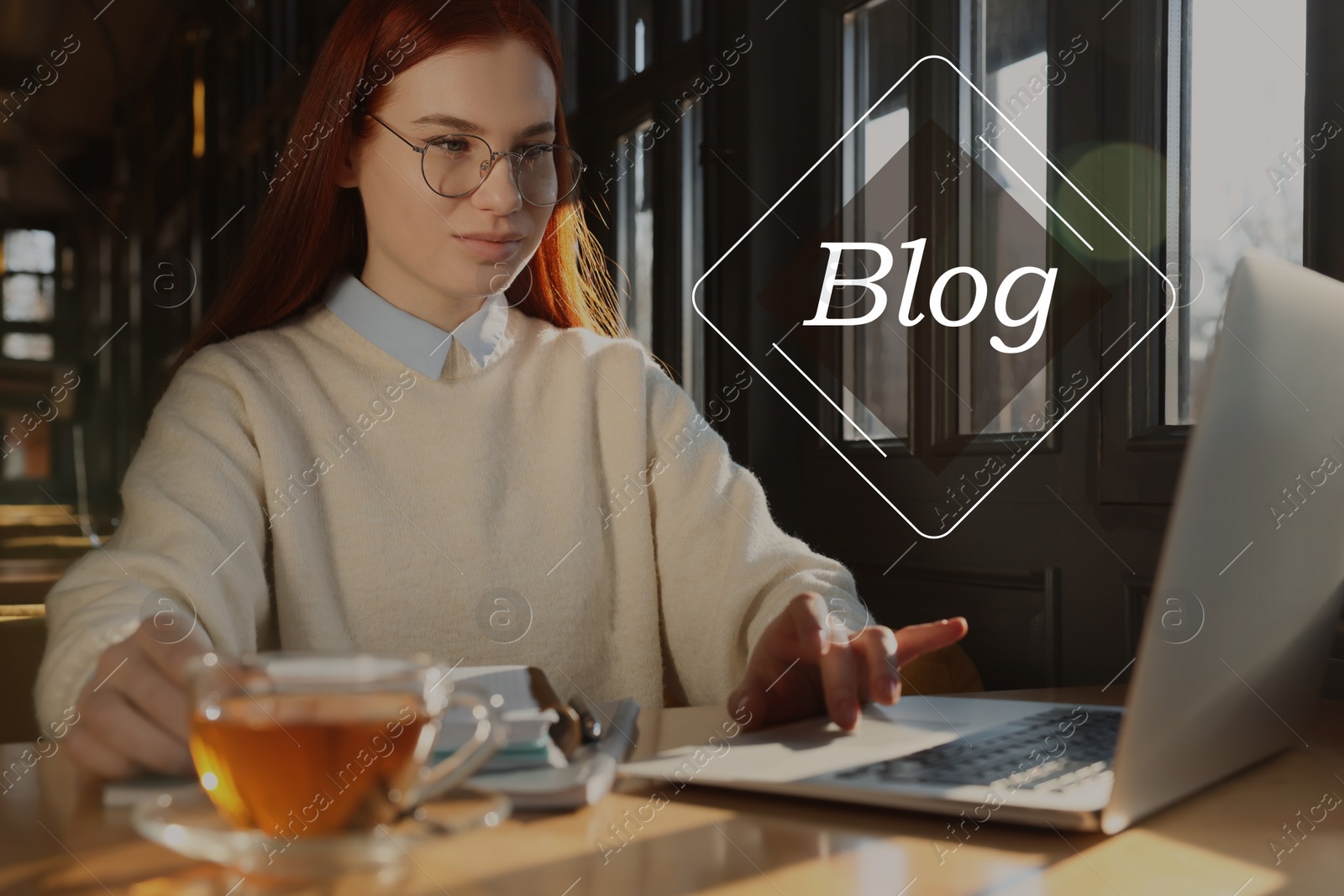 Image of Blogger working with laptop studying at table in cafe